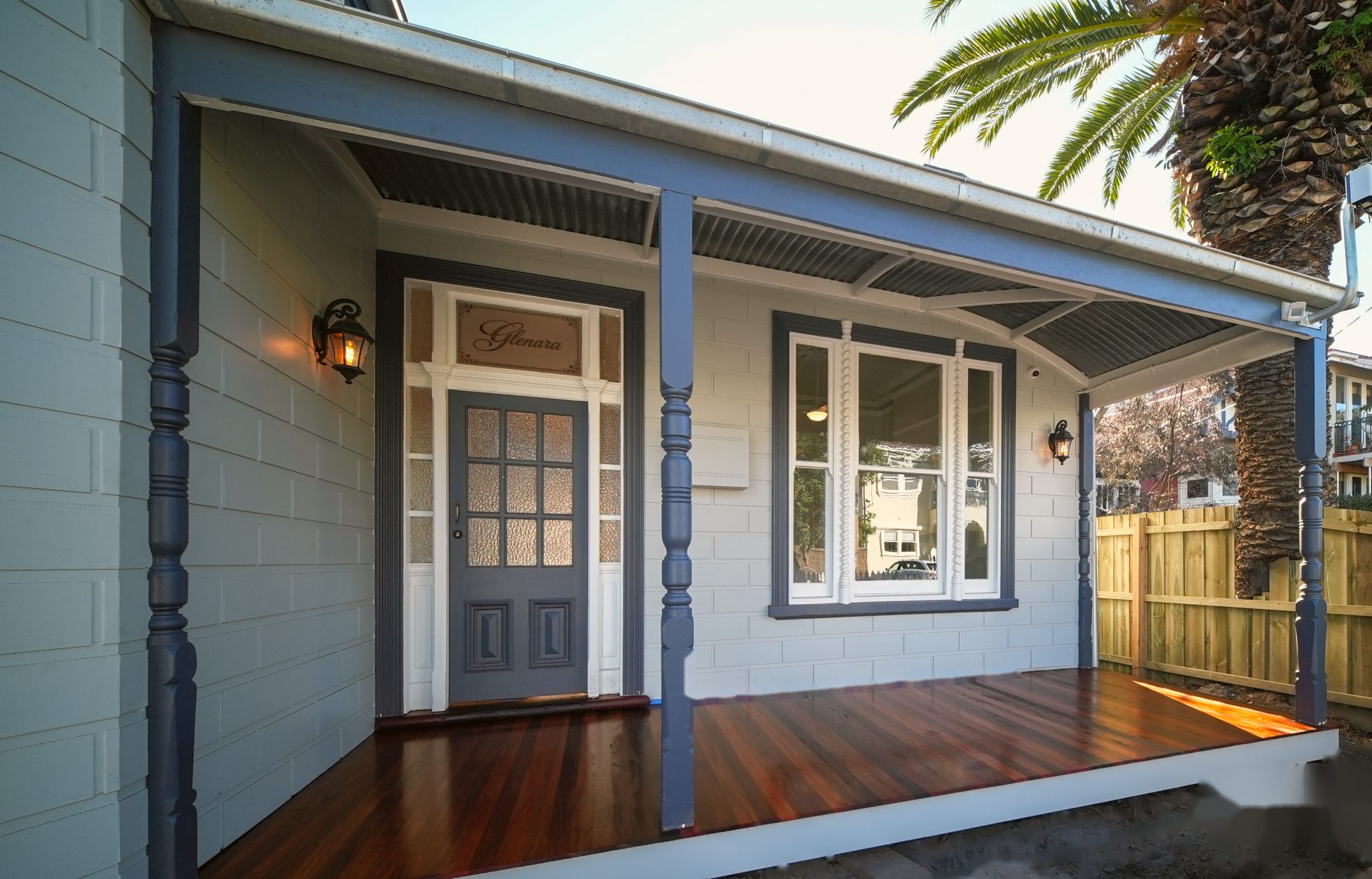 The front verandah with turned posts, a polished timber deck and the leadlight reading Glenara above the door