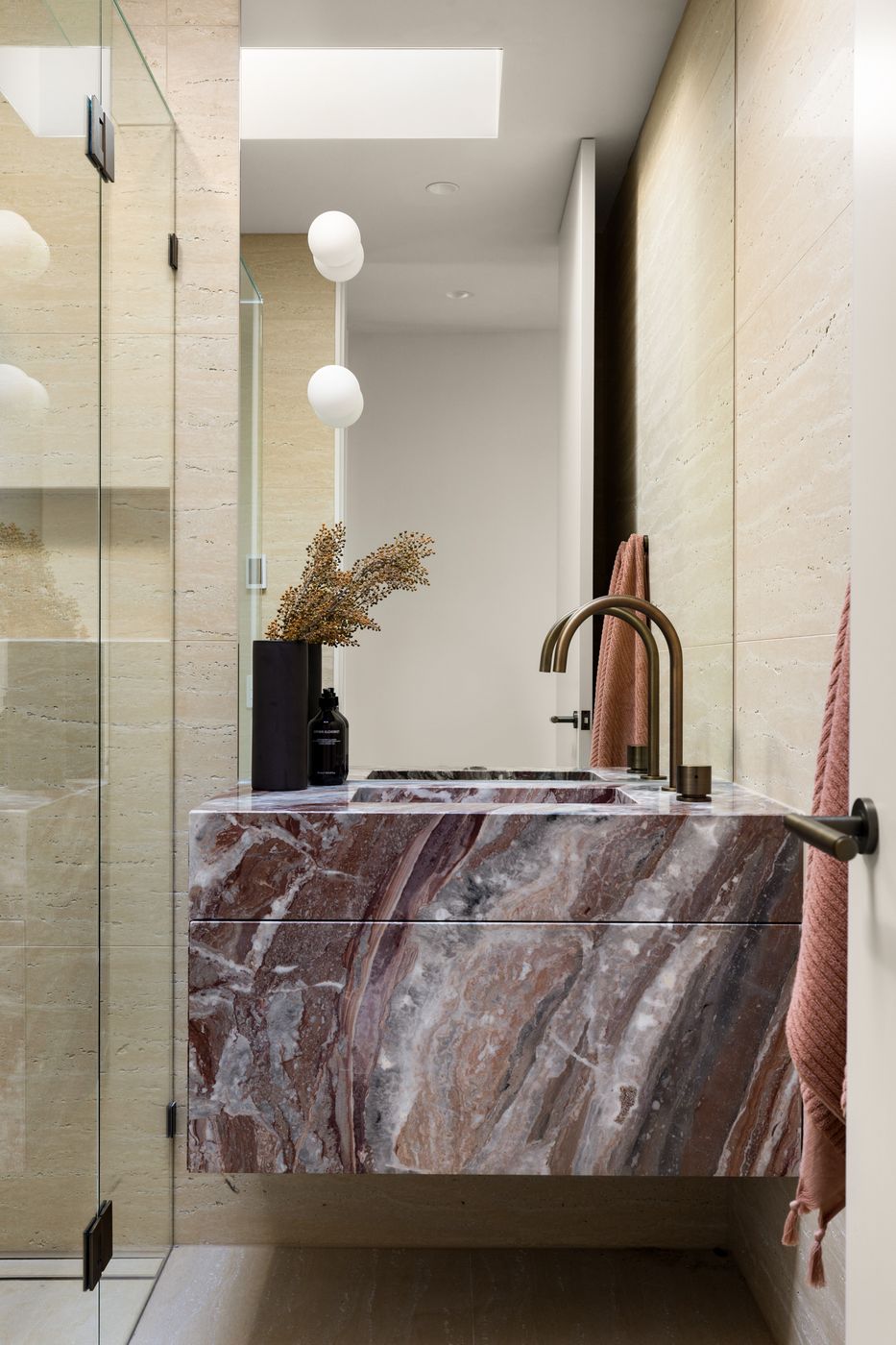 Powder room with a solid marble basin and brass tapware