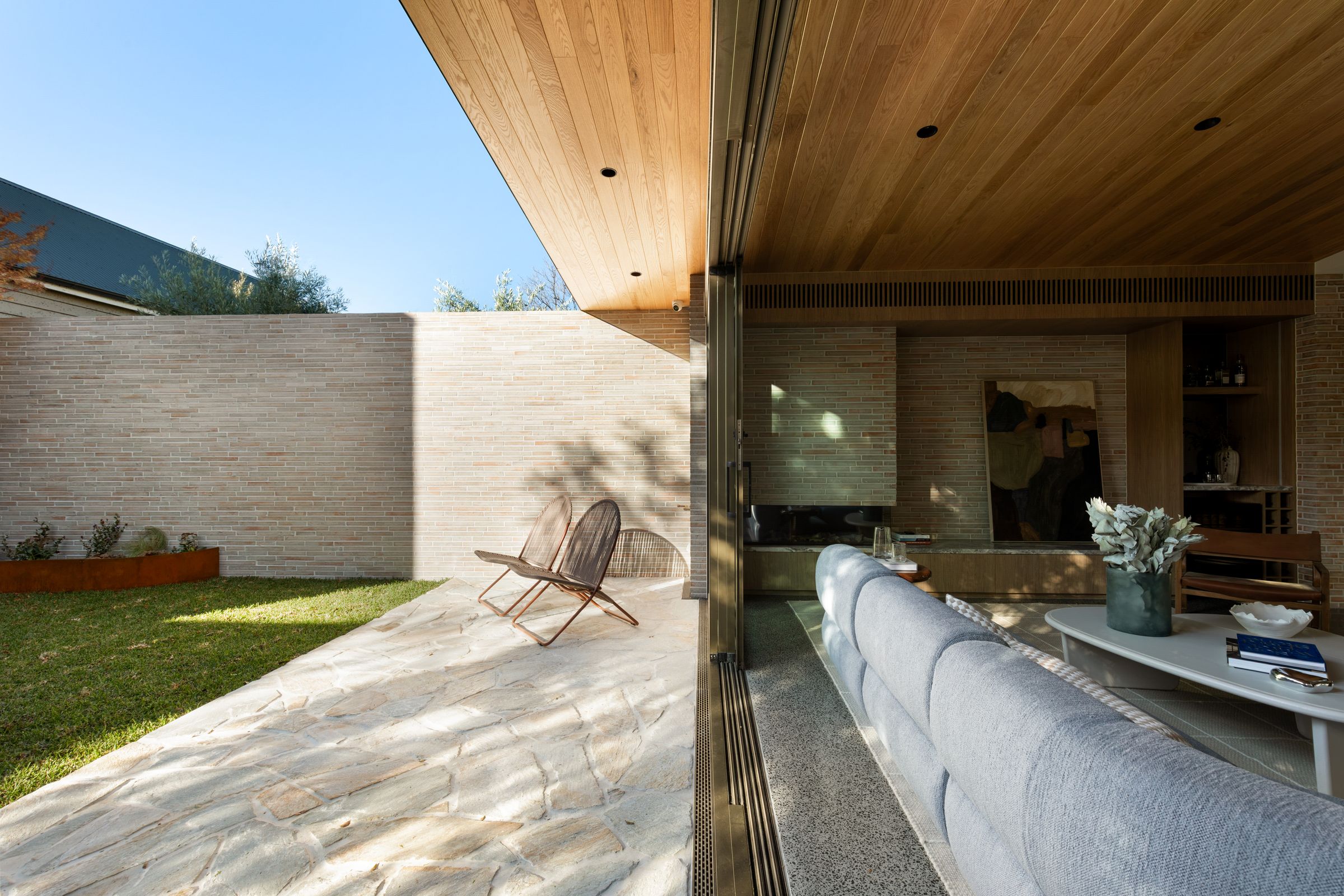 Sliding doors open the living room to the stone terrace and courtyard