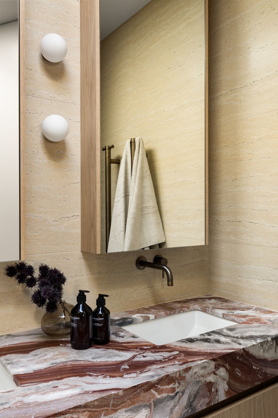 Detail of the marble vanity, brass tapware and globe wall lights