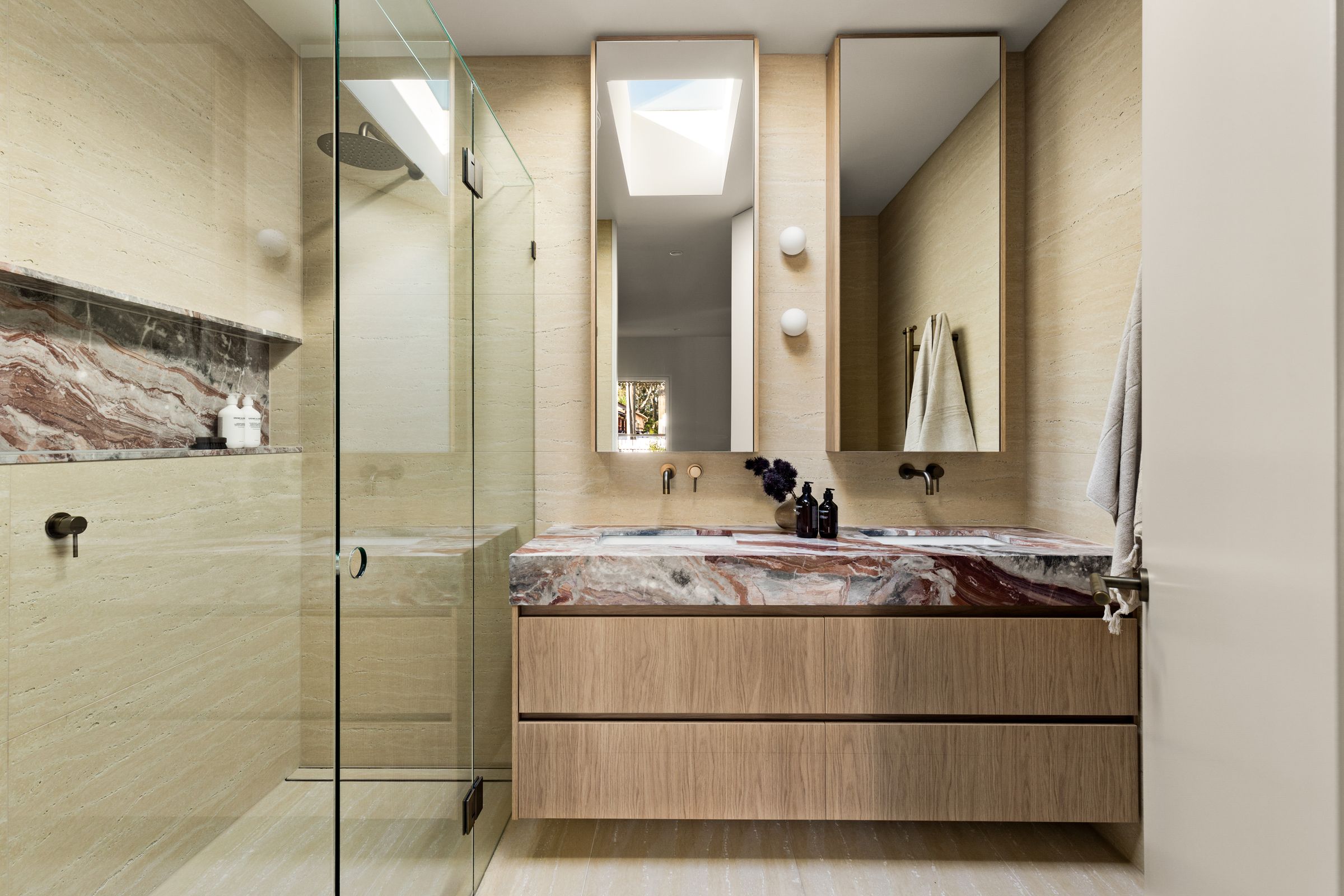 Bathroom in travertine with a red-veined marble vanity