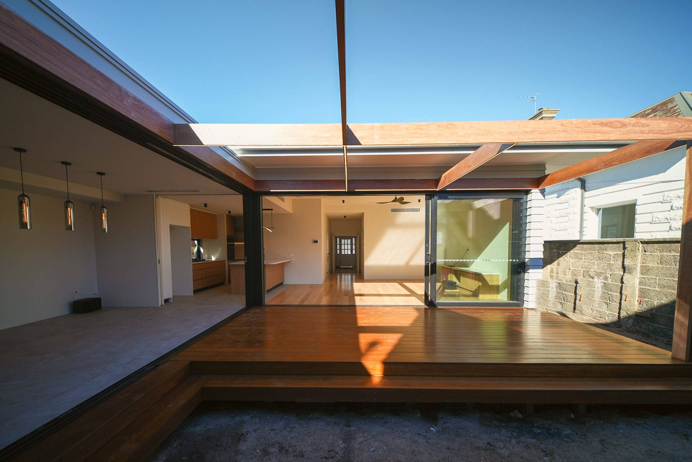 Glenara courtyard deck under a hardwood pergola, opening to the living spaces